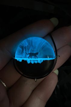 a person is holding a glowing object in their hand and it looks like a cat