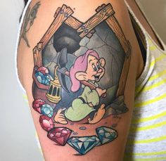 a woman's arm with an old school style cartoon character on it and diamonds