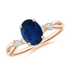 an oval blue sapphire and diamond ring with two white diamonds on the band, set in 18k rose gold