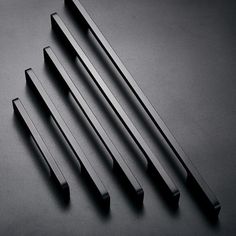 four black handles on a dark surface