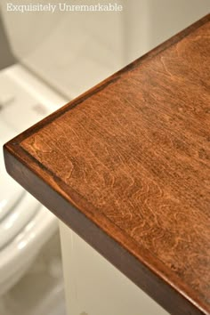 a wooden counter top in a bathroom next to a toilet