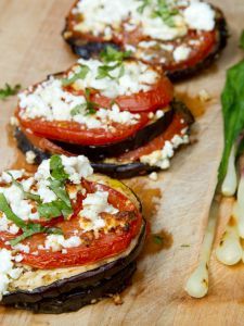 grilled eggplant, tomato and feta cheese sandwiches on a cutting board