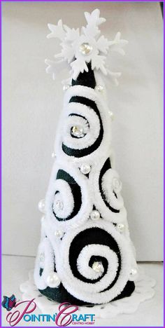 a white and black christmas tree with snowflakes on it's top is shown