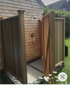 an outdoor shower in a backyard with rocks and stones on the ground next to it