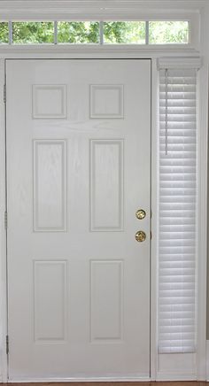 a white front door with blinds on the side