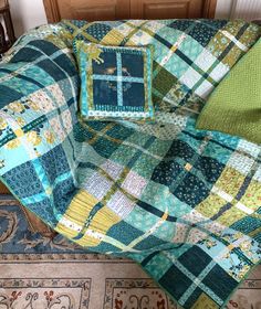 a blue and green quilt sitting on top of a wooden floor next to a rug