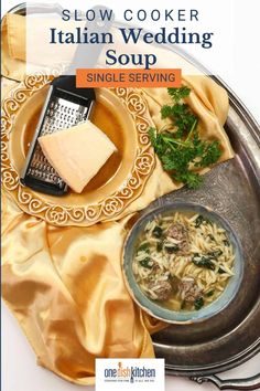 a plate with pasta and meat on it next to a bowl of soup, cheese and parsley