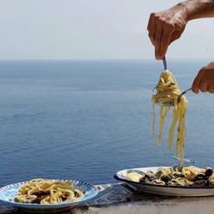 a person is eating some food by the ocean