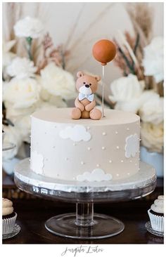 a teddy bear sitting on top of a white cake