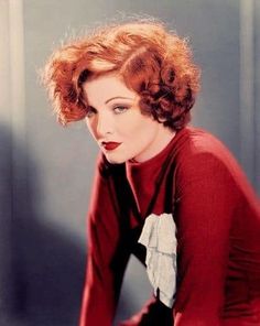 a woman with red hair is posing for a photo