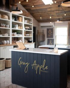 a kitchen with an island that says gray apple market in gold lettering on the counter