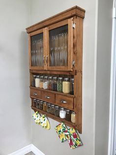 a wall mounted spice rack with glass doors