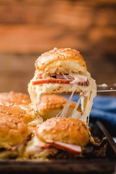 a close up of a sandwich being cut in half on a tray with other pastries