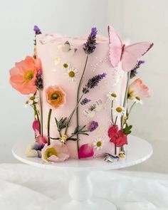 a pink cake decorated with flowers and butterflies