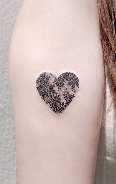 a woman's arm with a heart shaped tattoo on the left side of her arm