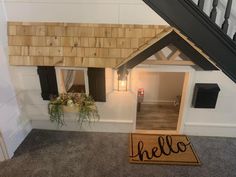 a dog house with the door open to let in some light and flowers on the porch