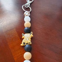 a wooden table with a keychain on it that has an animal charm attached to it