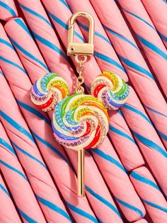 a colorful lollipop keychain on top of pink candy canes