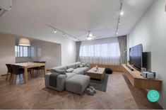 a living room filled with furniture and a flat screen tv on top of a wooden table