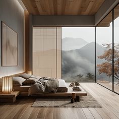 a bedroom with wood flooring and large windows looking out onto the mountain range in the distance