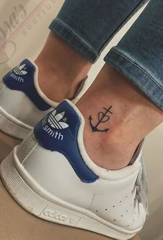 a person with a small anchor tattoo on their foot