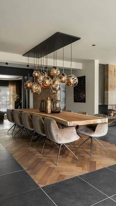 a dining room table with chairs and lights hanging from it's centerpieces