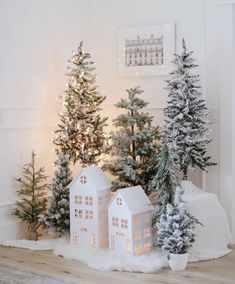 christmas trees and small houses are on the floor