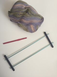 yarn, knitting needles and crochet hooks on a white surface