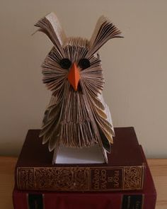 an owl made out of books sitting on top of a book