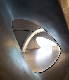 the interior of a building with curved concrete walls