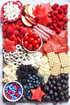 a platter filled with fruit, cheese and crackers