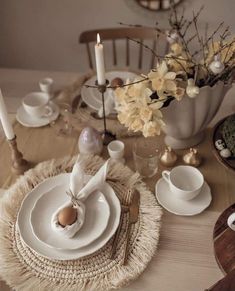 the table is set with dishes, cups and saucers