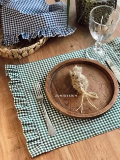 a place setting with napkins, fork and knife on a wooden tableclothed place mat