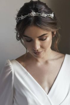 a woman wearing a white dress and a headband with crystal stones on the side