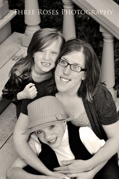 a woman and two children are posing for a photo on the steps with their arms around each other