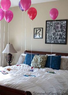 balloons floating from the ceiling over a bed