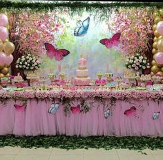 a pink and gold birthday party with butterflies on the wall, balloons and cake table