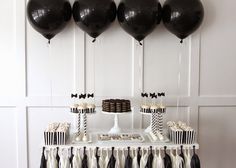 a dessert table with black and white decorations