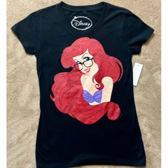 Add A Touch Of Disney Magic To Your Wardrobe With This Stylish Black Graphic Tee Featuring Ariel, The Beloved Mermaid. Made For Women And Juniors, This Size Small Tee Is Perfect For Any Fan Of The Iconic Disney Classic. The Shirt Is Made With High-Quality Materials, Ensuring It Will Last For Years To Come. The Shirt's Black Color And Graphic Design Make It A Versatile Addition To Any Outfit, Perfect For Casual Wear. Whether You're Heading To The Beach Or Just Running Errands, This Disney Tee Is Black Disney Short Sleeve Shirt, Disney Trips Character Print Short Sleeve Tops, Black Disney Fan Merchandise T-shirt, Disney Graphic Print Short Sleeve Top, Cheap Disney Short Sleeve T-shirt, Disney Tees, Disney Tops, Disney Ariel, Black Graphic Tees