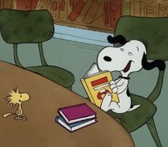 a cartoon dog reading a book while sitting at a table with a mouse on it