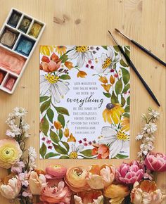 flowers and watercolor paints on a table with a card saying everything you need is love