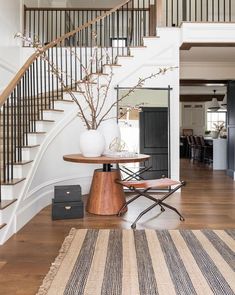 a living room with a stair case next to a table