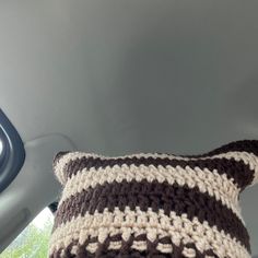 a crocheted pillow sitting in the back seat of a car