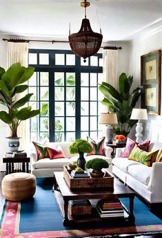 a living room filled with lots of furniture and plants on top of a blue rug