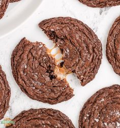 chocolate cookies with white frosting and caramel drizzled in the middle