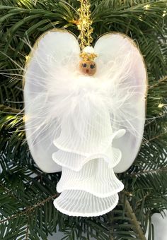 an angel ornament hanging from a christmas tree