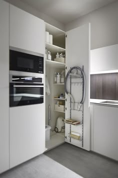 a kitchen with white cabinets and appliances in it's center wall, along with shelves on both sides