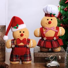 two teddy bears dressed in red and plaid outfits, standing next to each other near a christmas tree