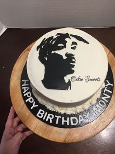 a birthday cake with the image of a man's face on it is being held by a person