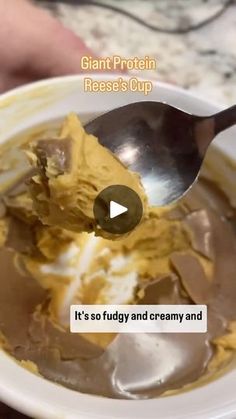 a bowl of ice cream with a spoon in it that is being held by someone's hand